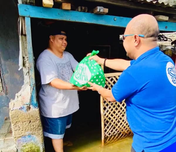 VOLUNTEER of SM Foundation hands a relief pack to a resident near SM City Pampanga affected by flood.